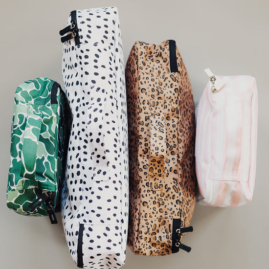 A combination of Brixley Bags packing cubes consisting of one (1) small camouflage (Scout) packing cube, one (1) large Dalmation print packing cube, one (1) medium cheetah print (Wild Thing) packing cube, and one (1) small pink striped (Valentine) packing cube