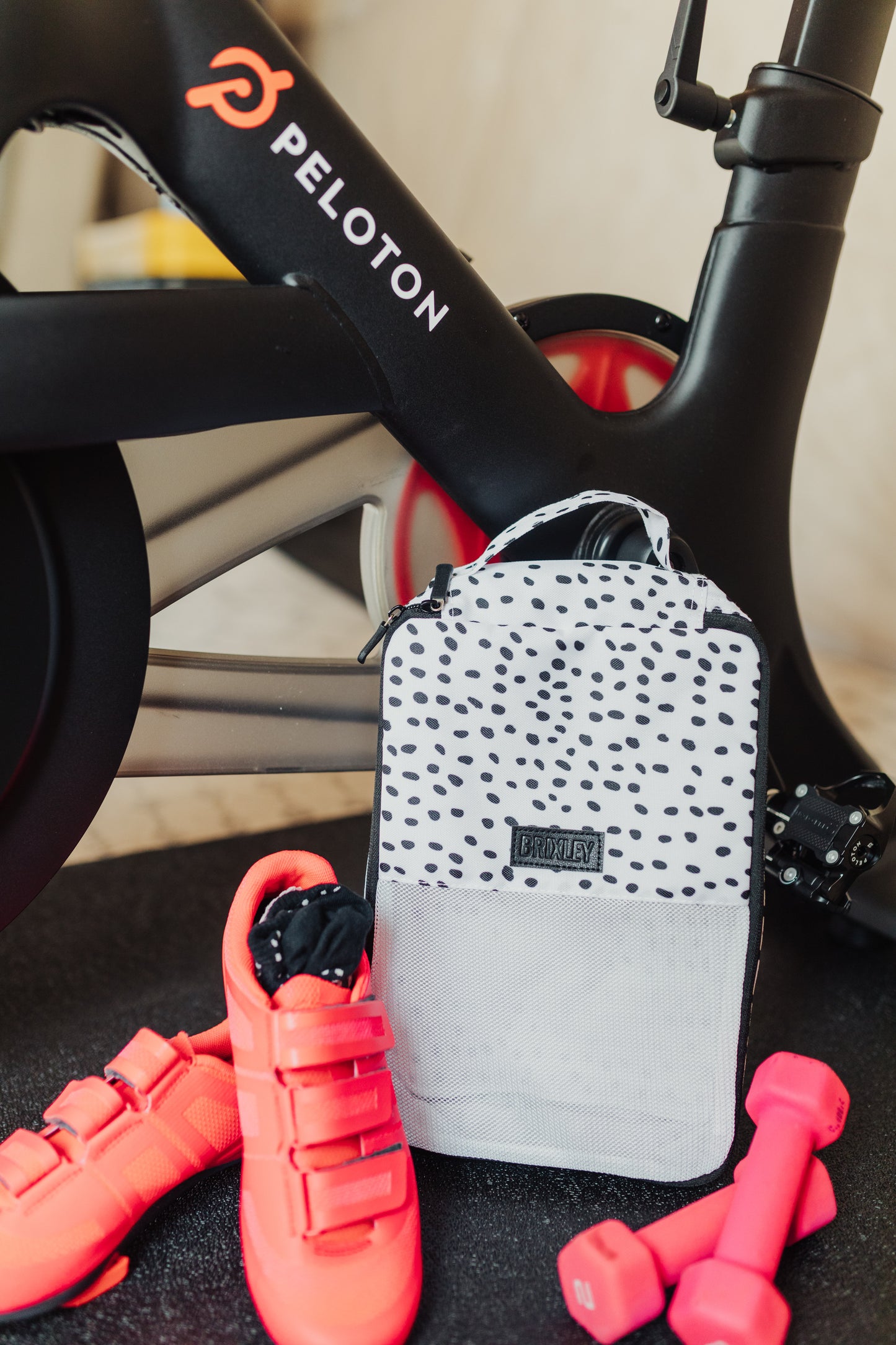 Dalmatian print Brixley Bags Packing Cube sitting next to pink workout gear and a Peloton